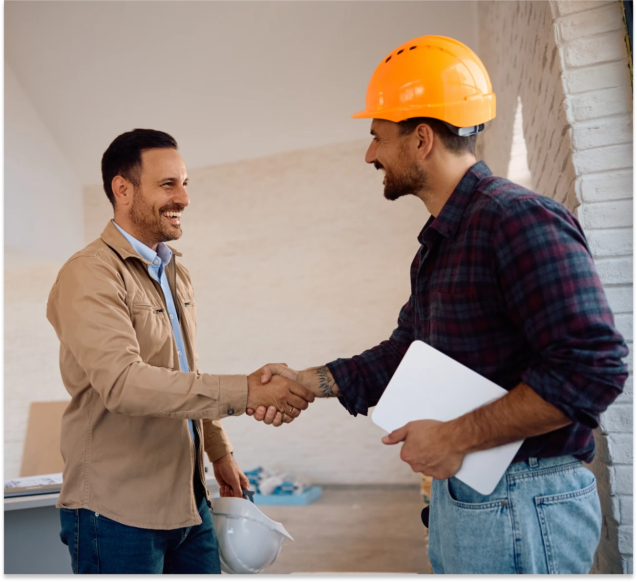 Two men in hard hats shaking hands