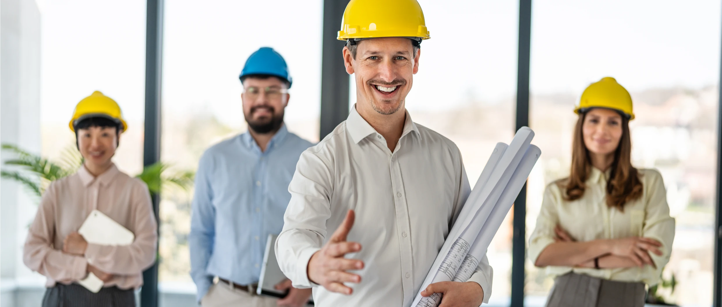 Engineers wearing helmets in an office